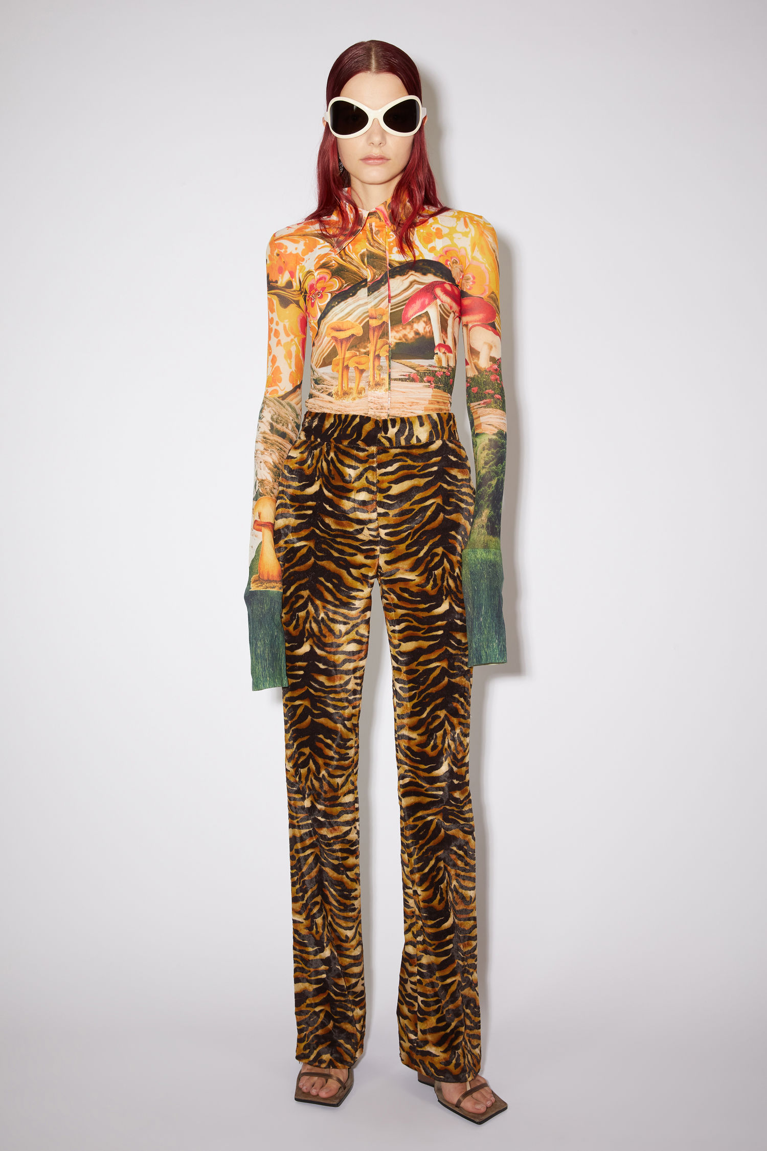 Acne Studios orange/black tailored trousers made of tiger print velvet with a tailored bootcut fit.